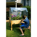 boy doing gardening work with the Eden elevated garden table with heavy duty enclosure