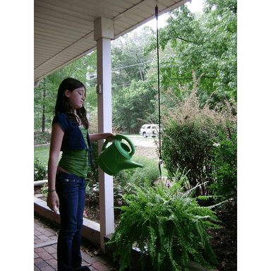 girl watering plant hanging with the help of the plant caddie 
