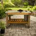 front view of the lee display gardener's pro potting table and it is placed in a garden