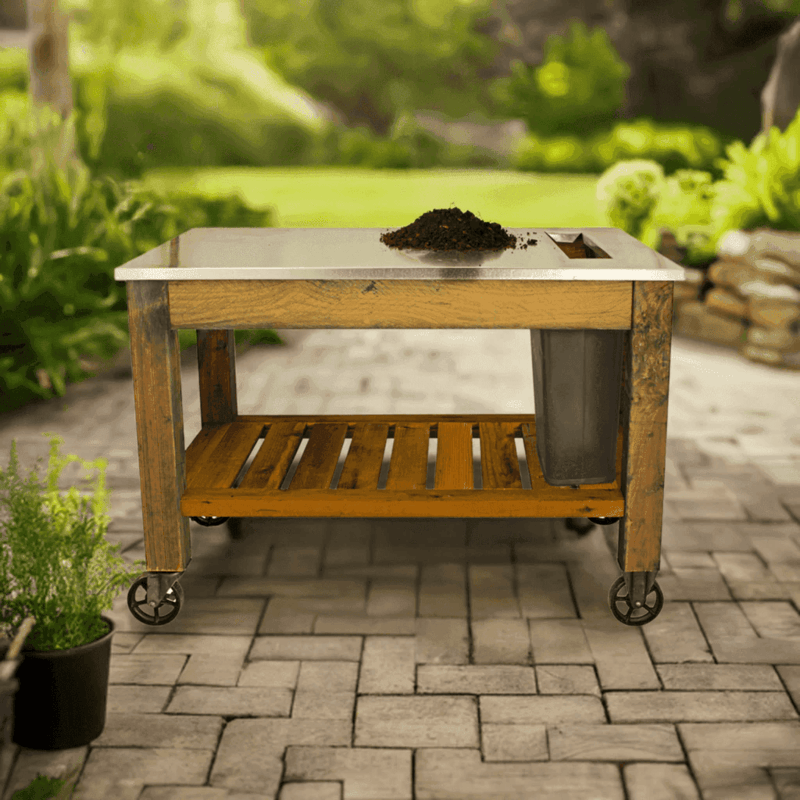 front view of the lee display gardener's pro potting table and it is placed in a garden