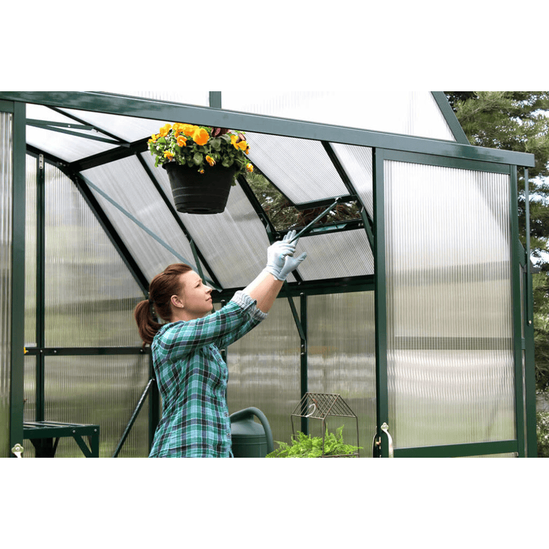 woman adjusting roof vents of grandio elite 8x24 greenhouse