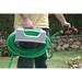 Person holding a coiled green hose with a holder of the riverstone outdoor sink