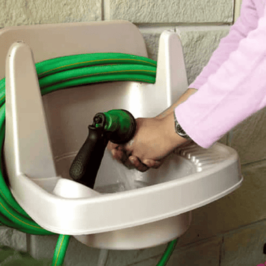 image of a person washing hands in a riverstone outdoor sink