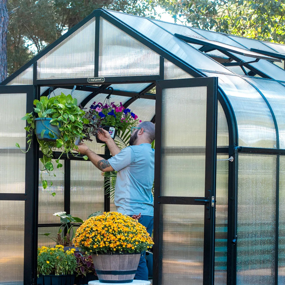 vego garden pacific greenhouse with a gardener in it working with plants