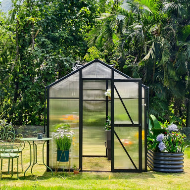 Front view of the Vego Junior Victorian 6.5ft greenhouse with its open single door and translucent polycarbonate panels in a garden.