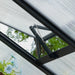 Close-up of Vego Junior Victorian Greenhouse manually adjustable roof vent showing the opening mechanism, metal support arm, and polycarbonate glazing