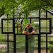 Gardener tending a potted plant through the independently opened upper Dutch-style doors of the Vego Pacific greenhouse