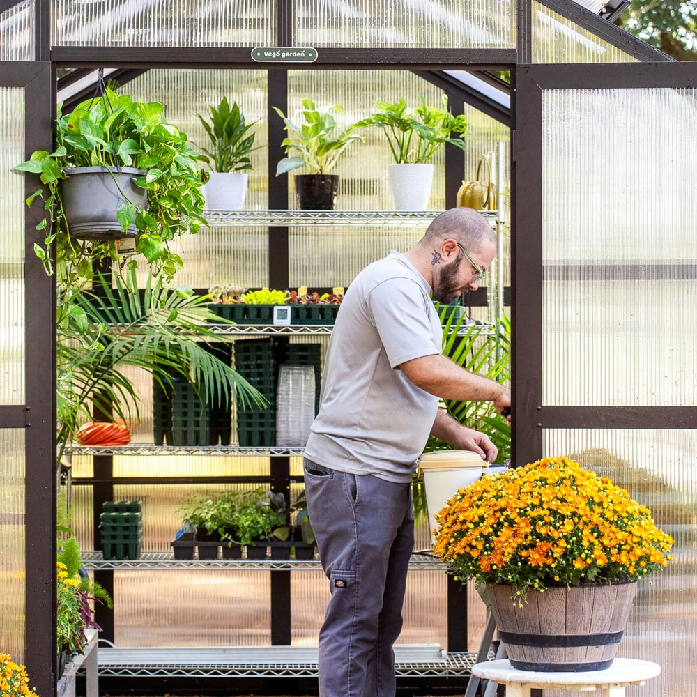 vego pacific 8.5 feet wide greenhouse with gardener in it